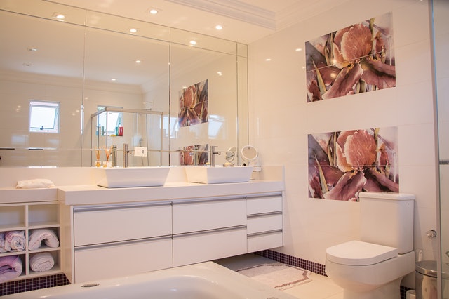 Kúpeľňa v bielych farbách s obrazom na stene a veľkým zrkadlom.jpg