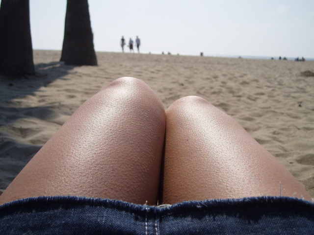 Žena v krátkej sukni leží na pláži